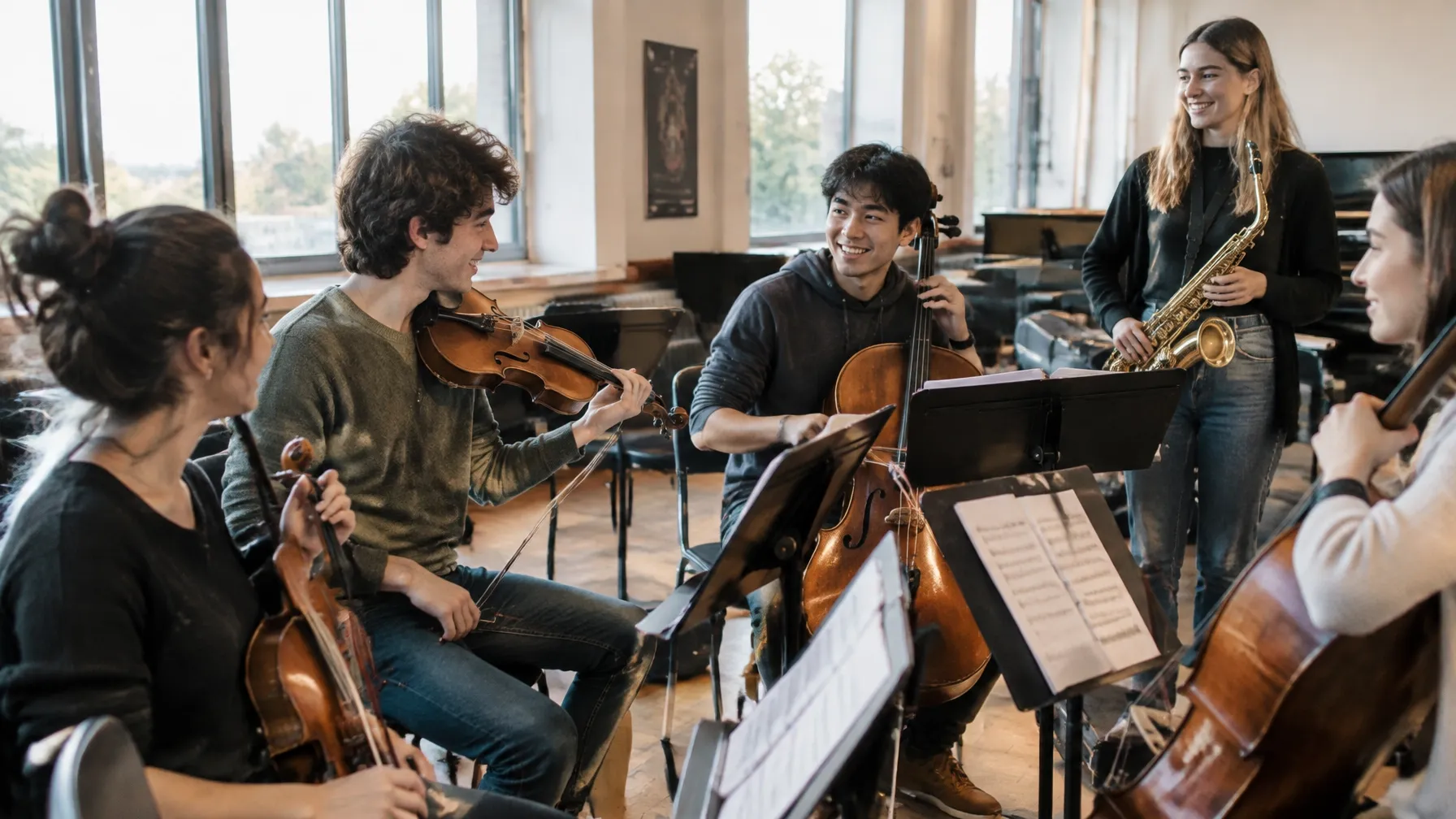 Jóvenes músicos ensayan juntos en una sala iluminada